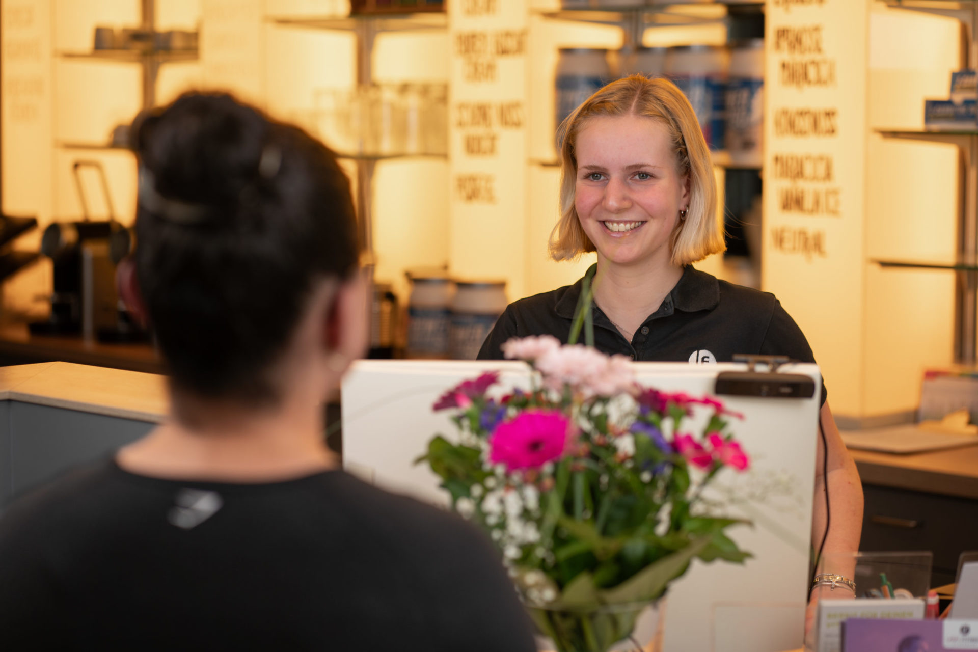 Bei LADY Fitness Oldenburg begrüßt du unsere Mitglieder, wie auf dem Bild zu sehen, mit einem herzlichen Lächeln und sorgst für eine einladende Atmosphäre. Als Teil unseres Teams bist du die erste Anlaufstelle und machst den Studio-Besuch zu einem besonderen Erlebnis. Werde Teil unseres freundlichen Teams und gestalte jeden Tag positiv mit!